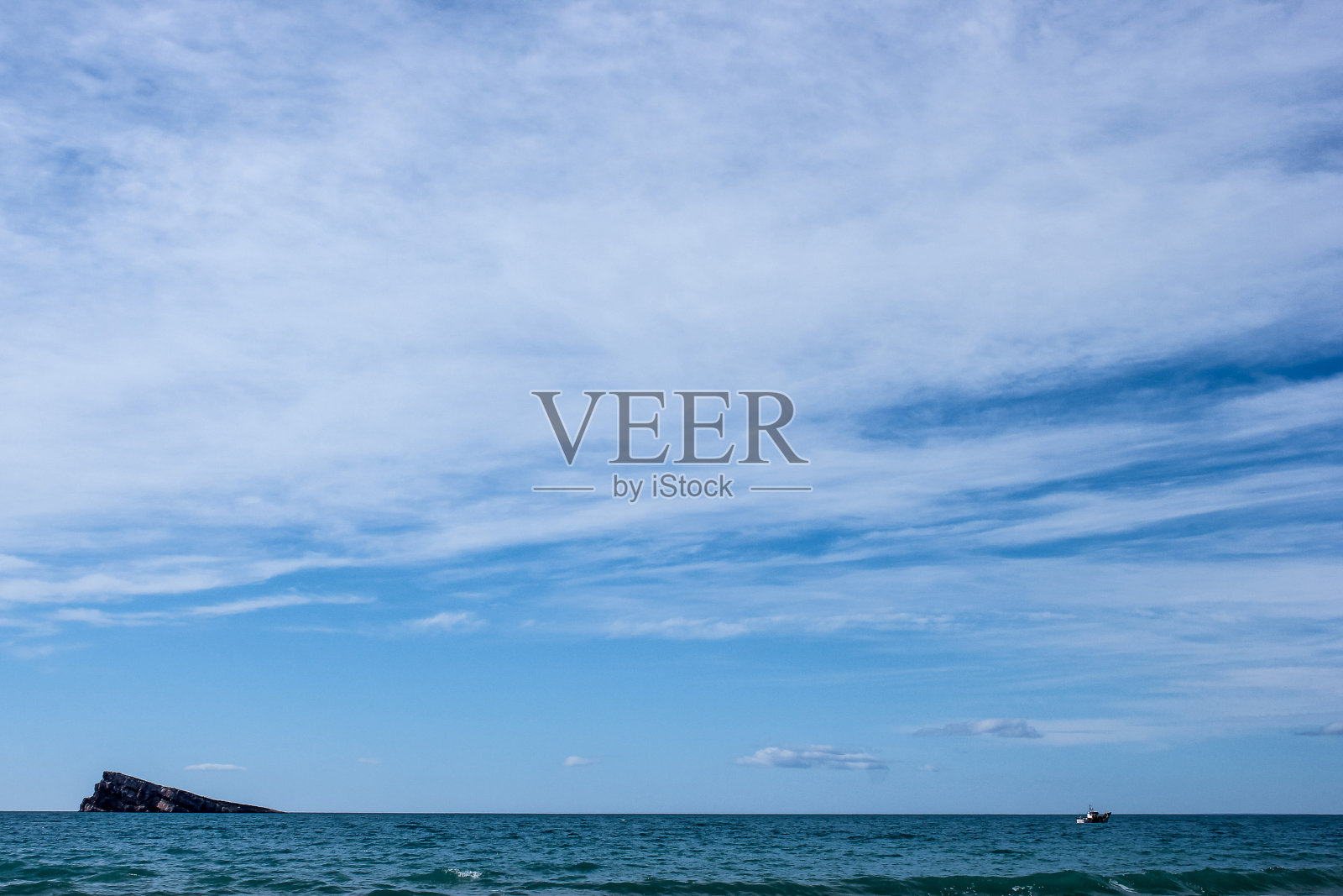 石岛在海上和小船照片摄影图片