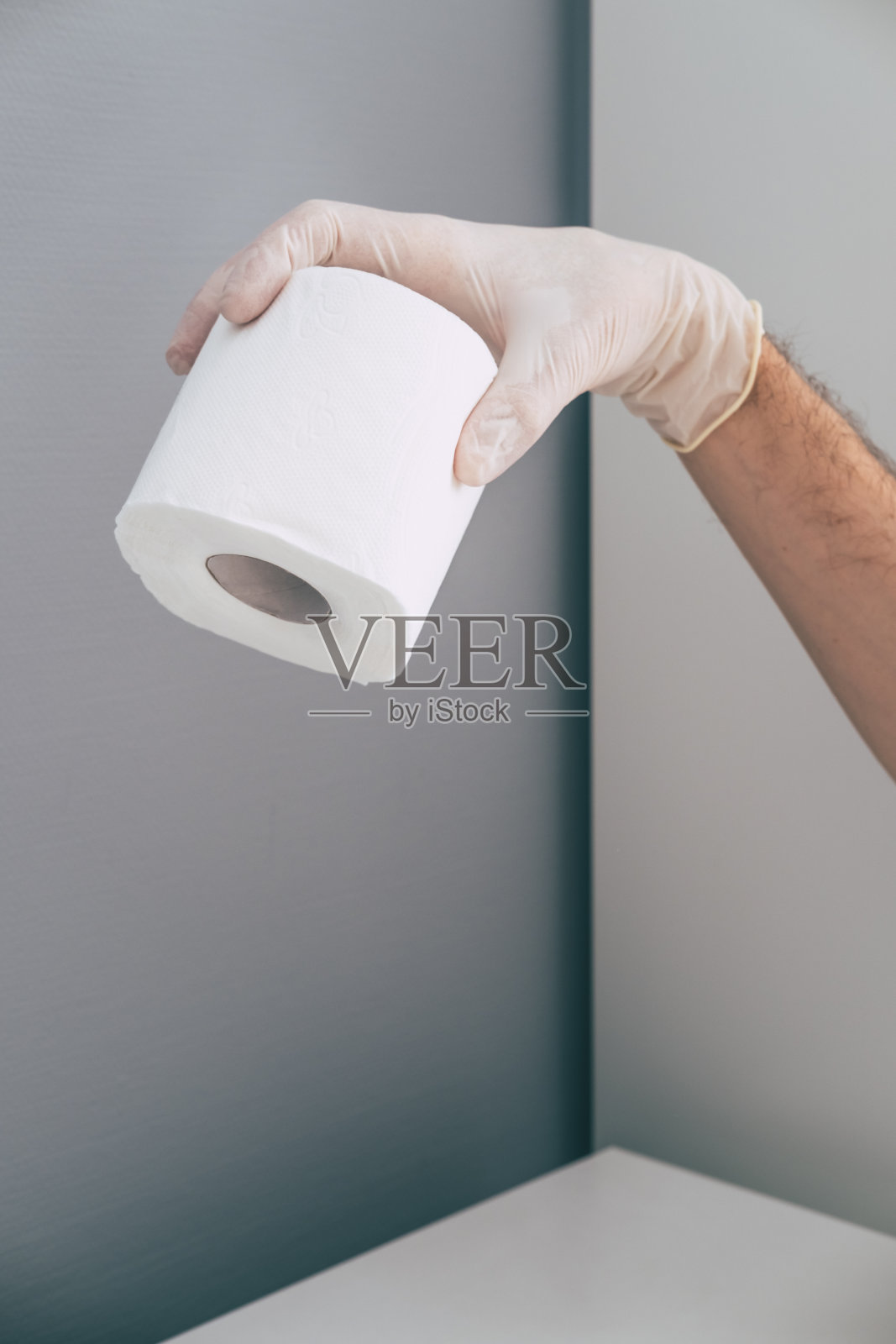 一名医护人员戴着橡胶手套，手里拿着卫生纸卷。冠状病毒恐慌的概念。等距和几何风格。照片摄影图片