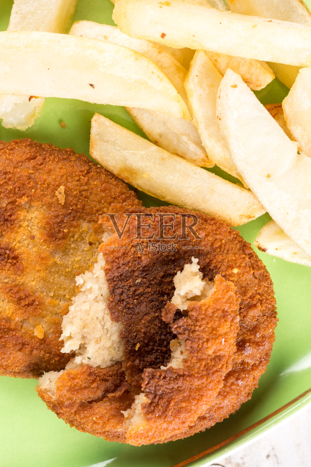 炸鱼、肉、汉堡和炸薯条放在盘子里照片摄影图片