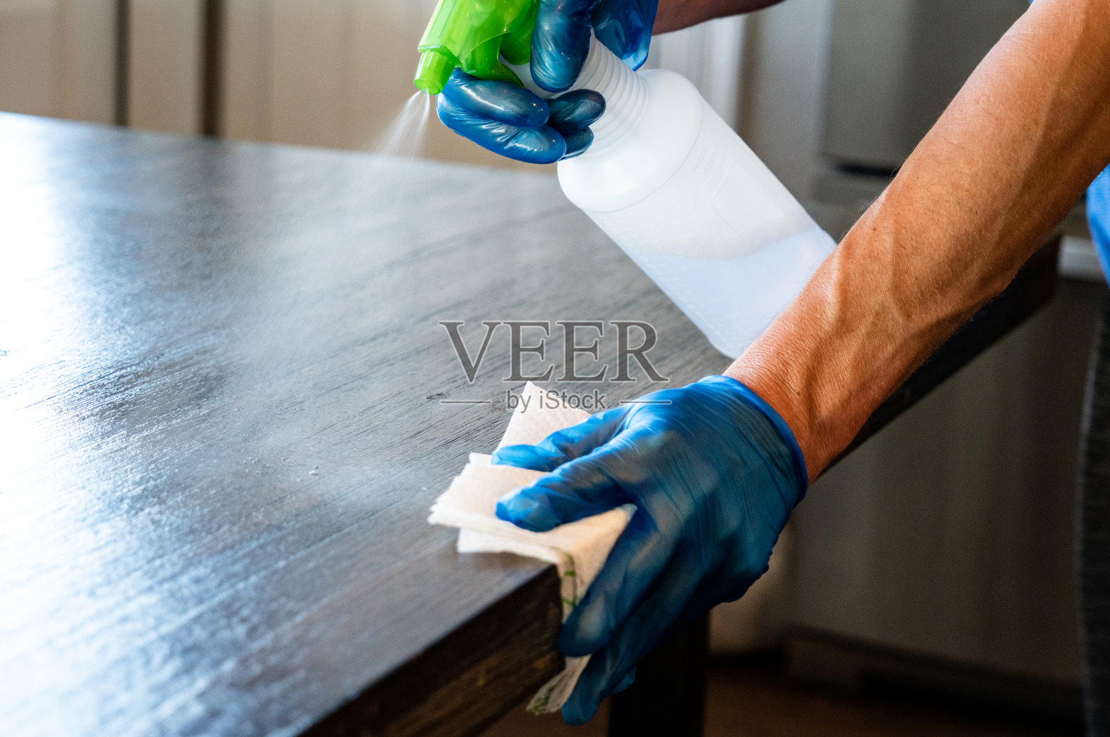 为Covid-19擦拭桌子的人照片摄影图片