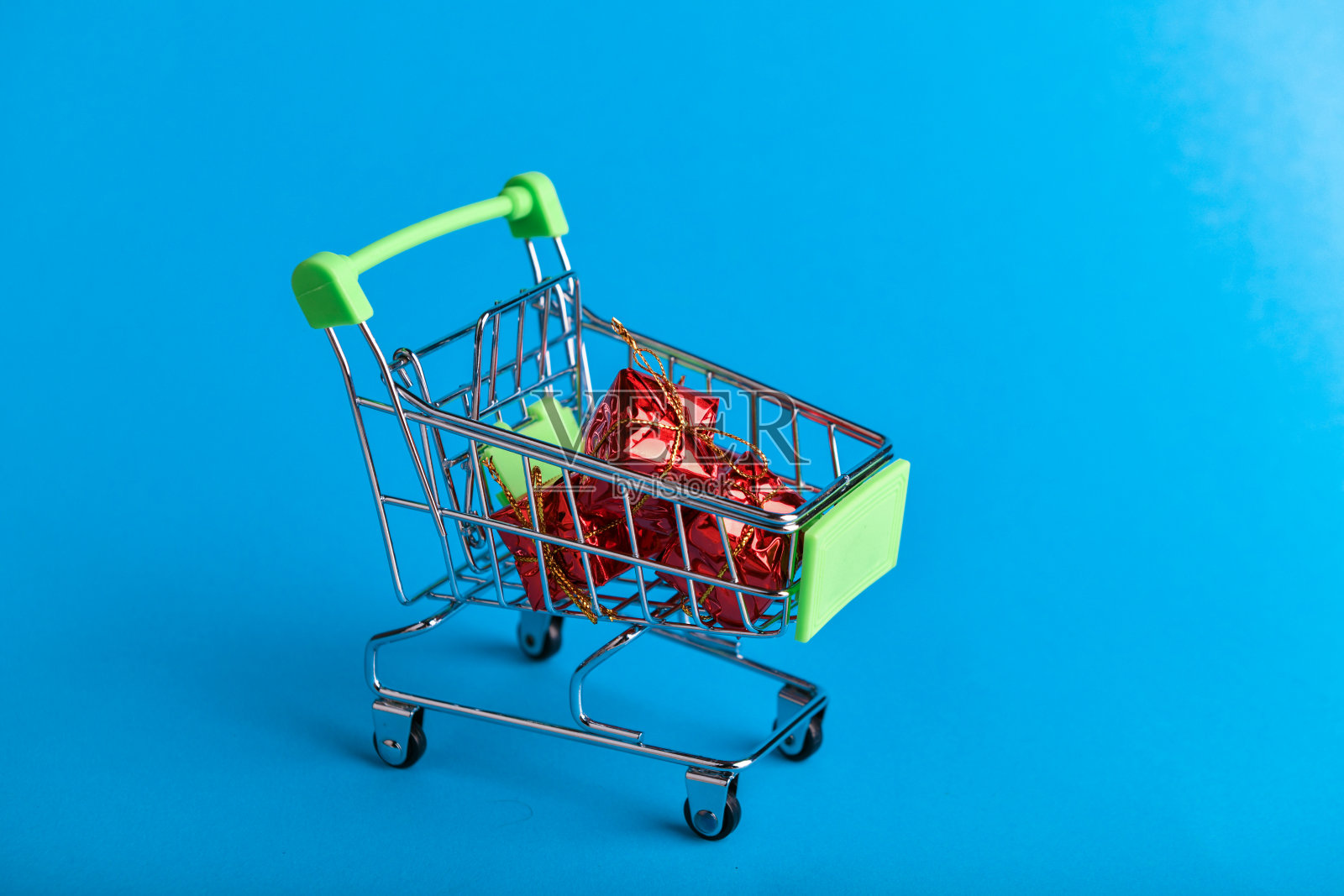 圣诞礼物购物理念。篮子和圣诞装饰品。装礼物的圣诞篮子。Onlain购物。在蓝色背景上。写的地方照片摄影图片