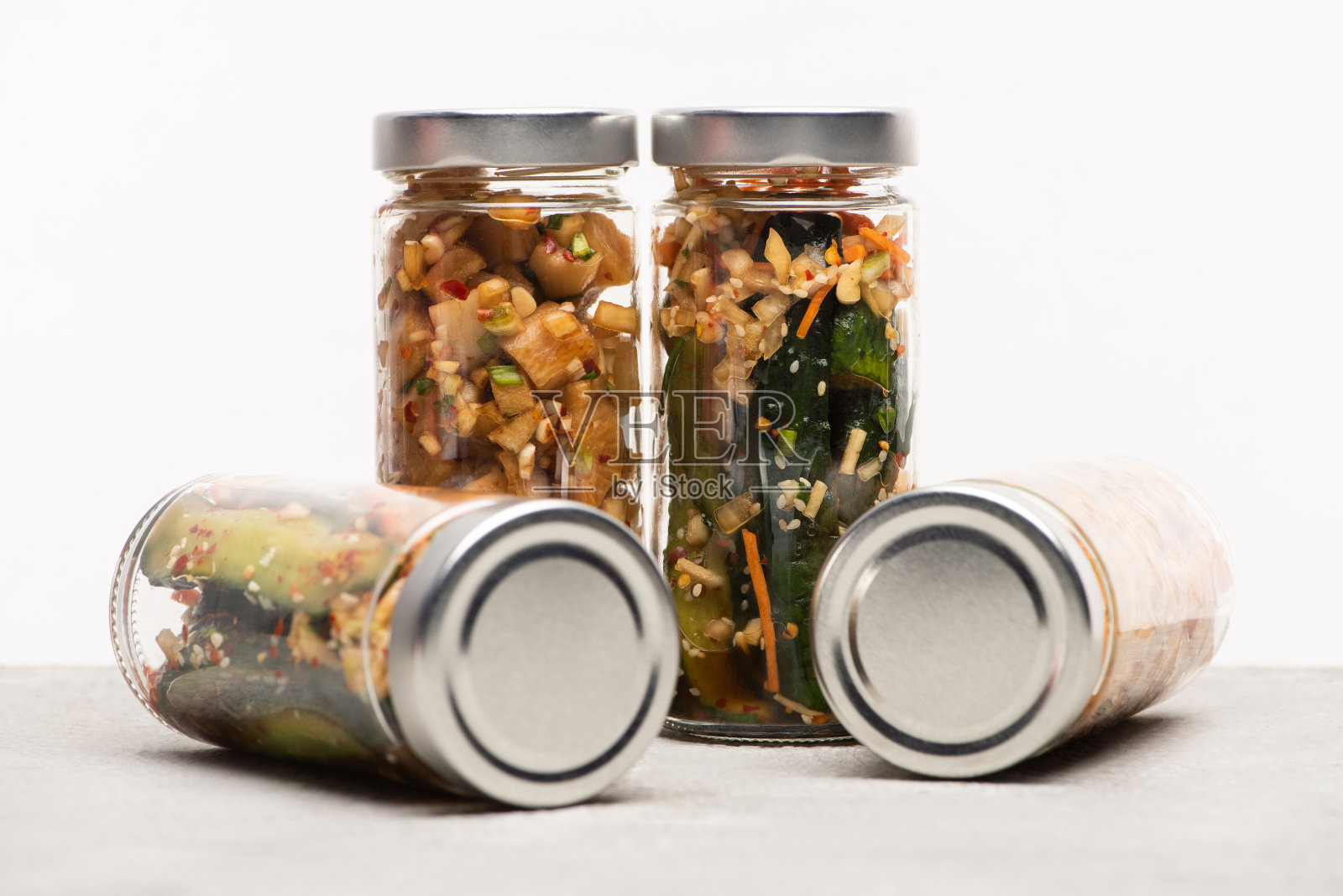 美味的黄瓜和萝卜泡菜在玻璃罐上隔离白色照片摄影图片