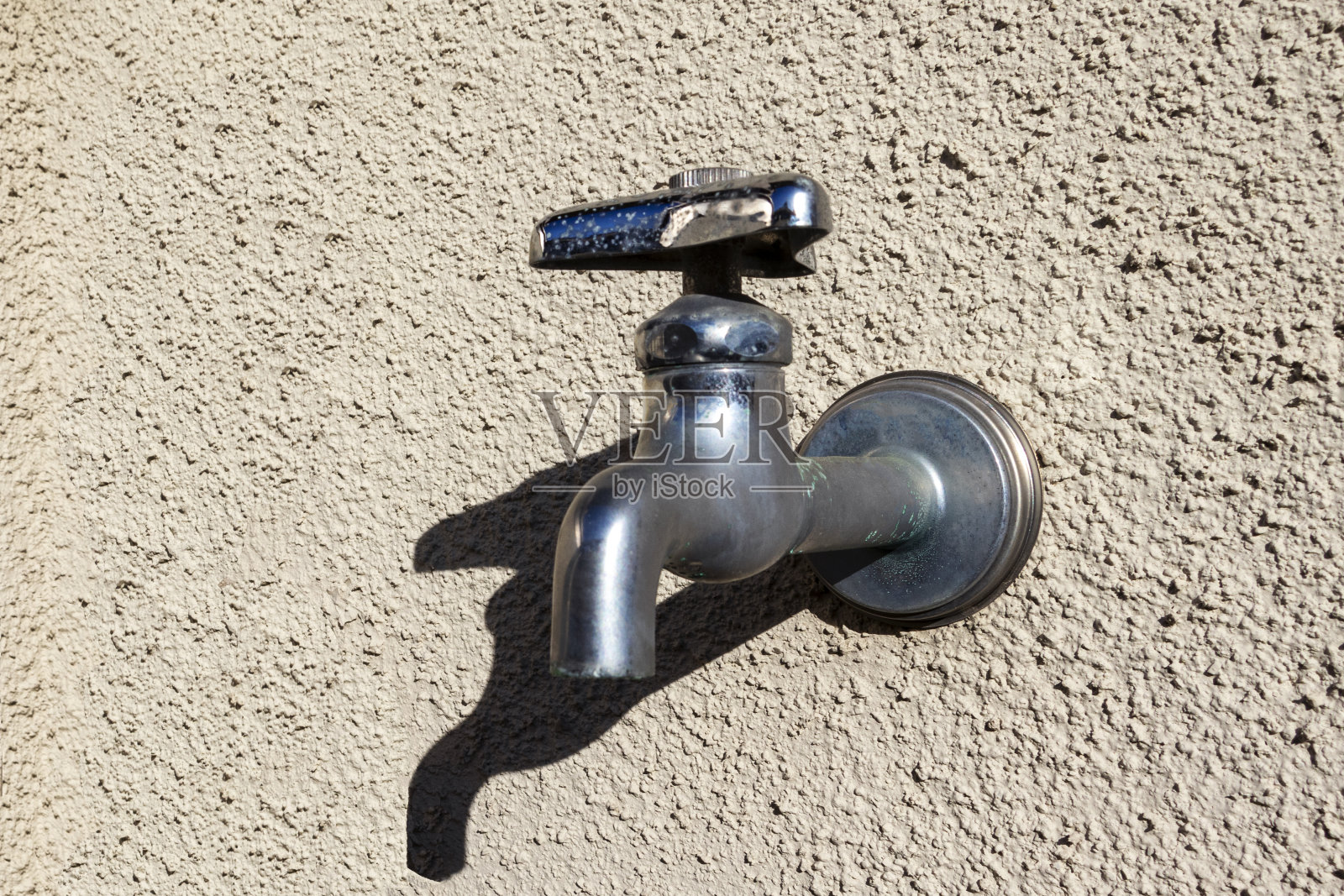 手动水龙头在墙上照片摄影图片