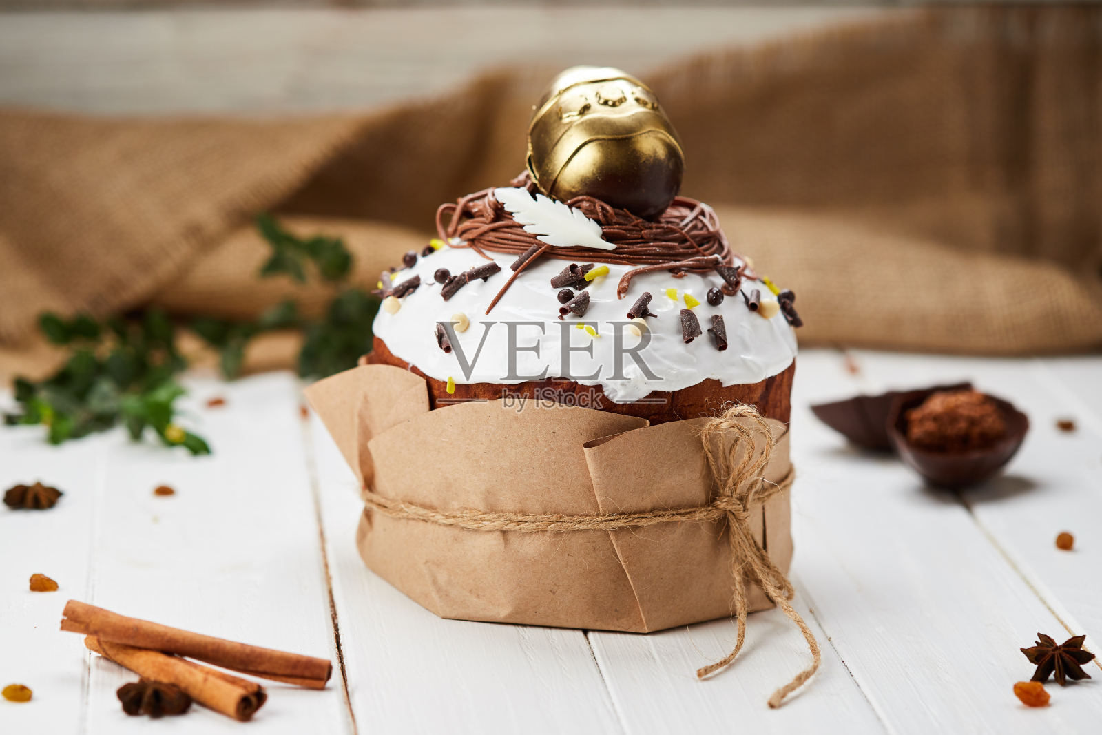 复活节蛋糕由金色的巧克力蛋装饰，白色的木制背景，传统的Kulich, Paska准备庆祝照片摄影图片