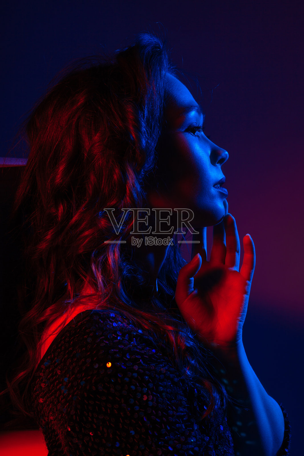 一个迷人的黑发女人穿着一件明亮的红蓝色裙子照片摄影图片