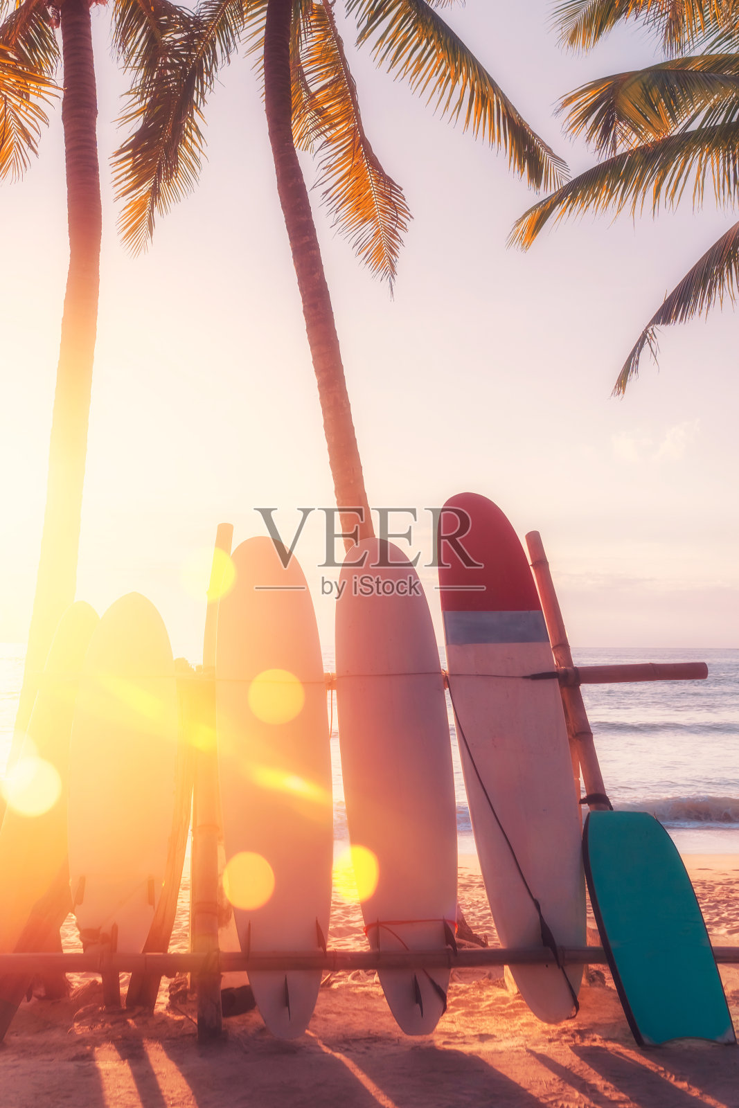 海滩上的冲浪板和棕榈树双重曝光，阳光光线纹理抽象的背景。照片摄影图片