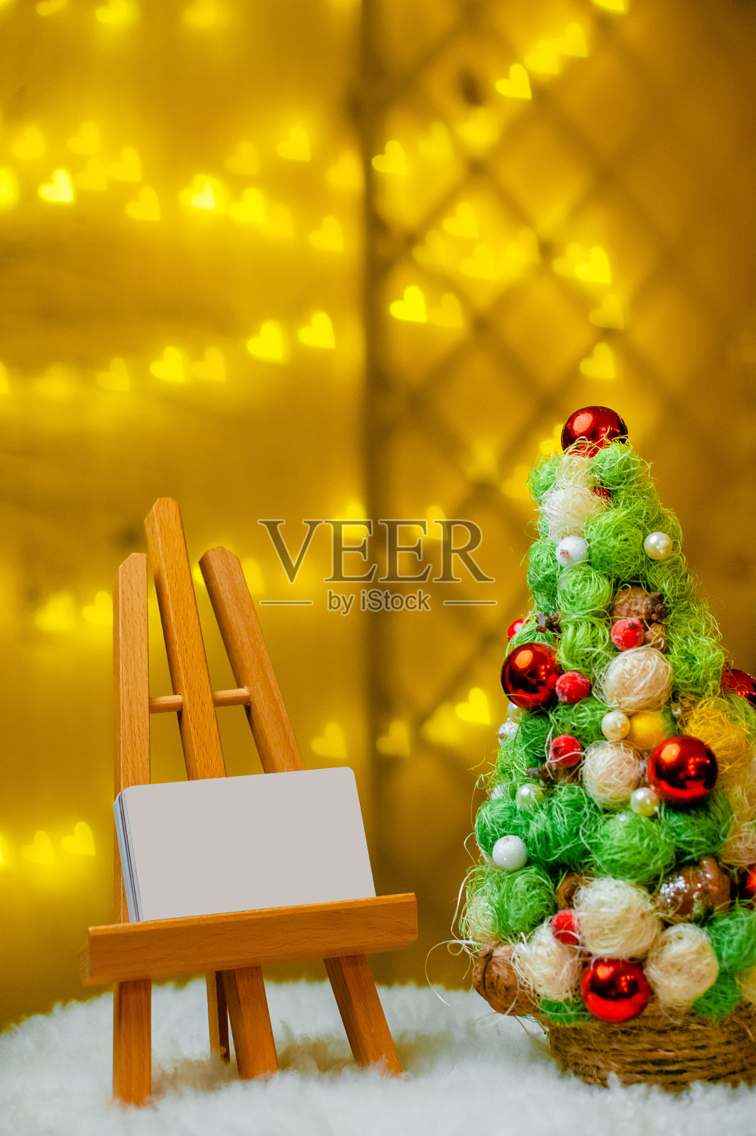 黄色背景上的圣诞树和画架照片摄影图片