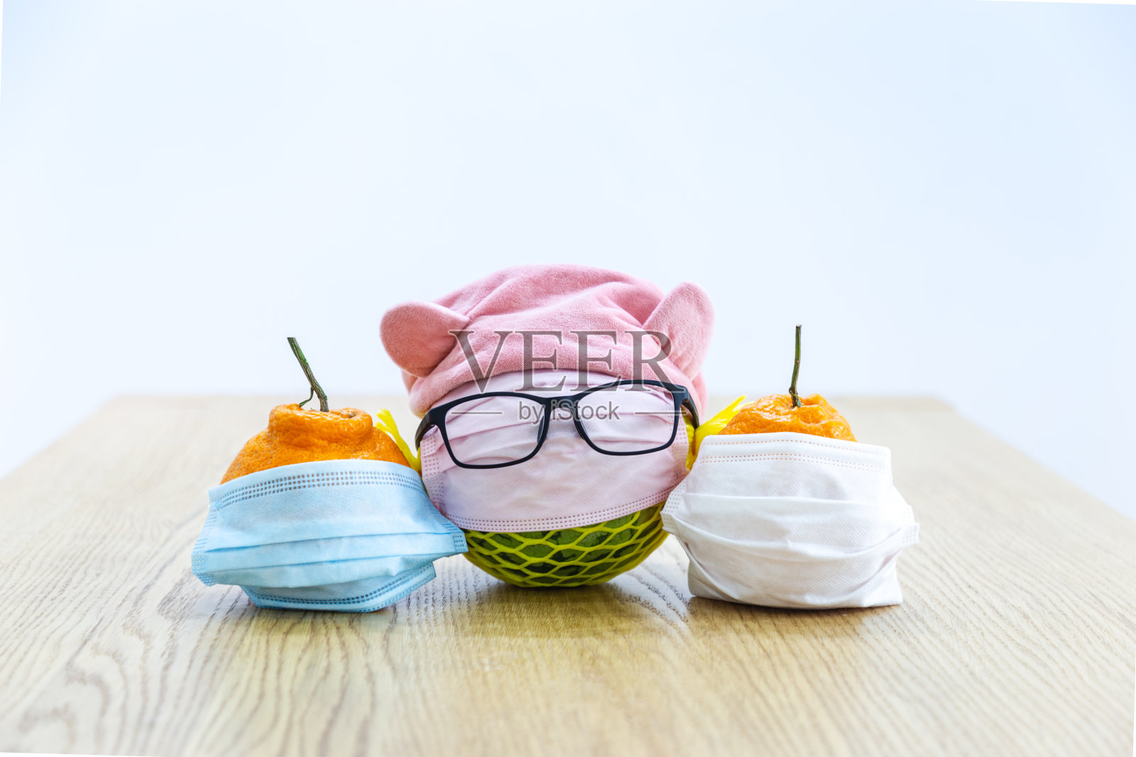 一些水果放在木桌上，戴着一次性医用口罩照片摄影图片