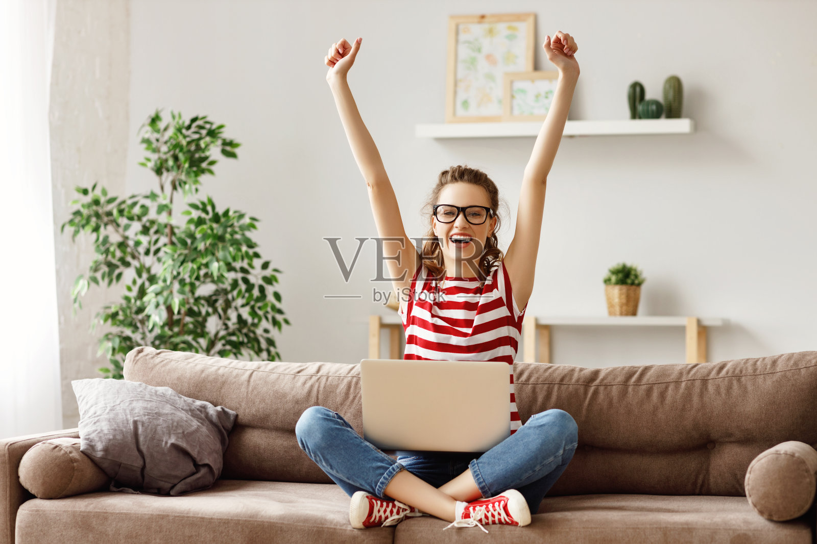 一个在家用笔记本电脑工作的女人在庆祝好消息照片摄影图片