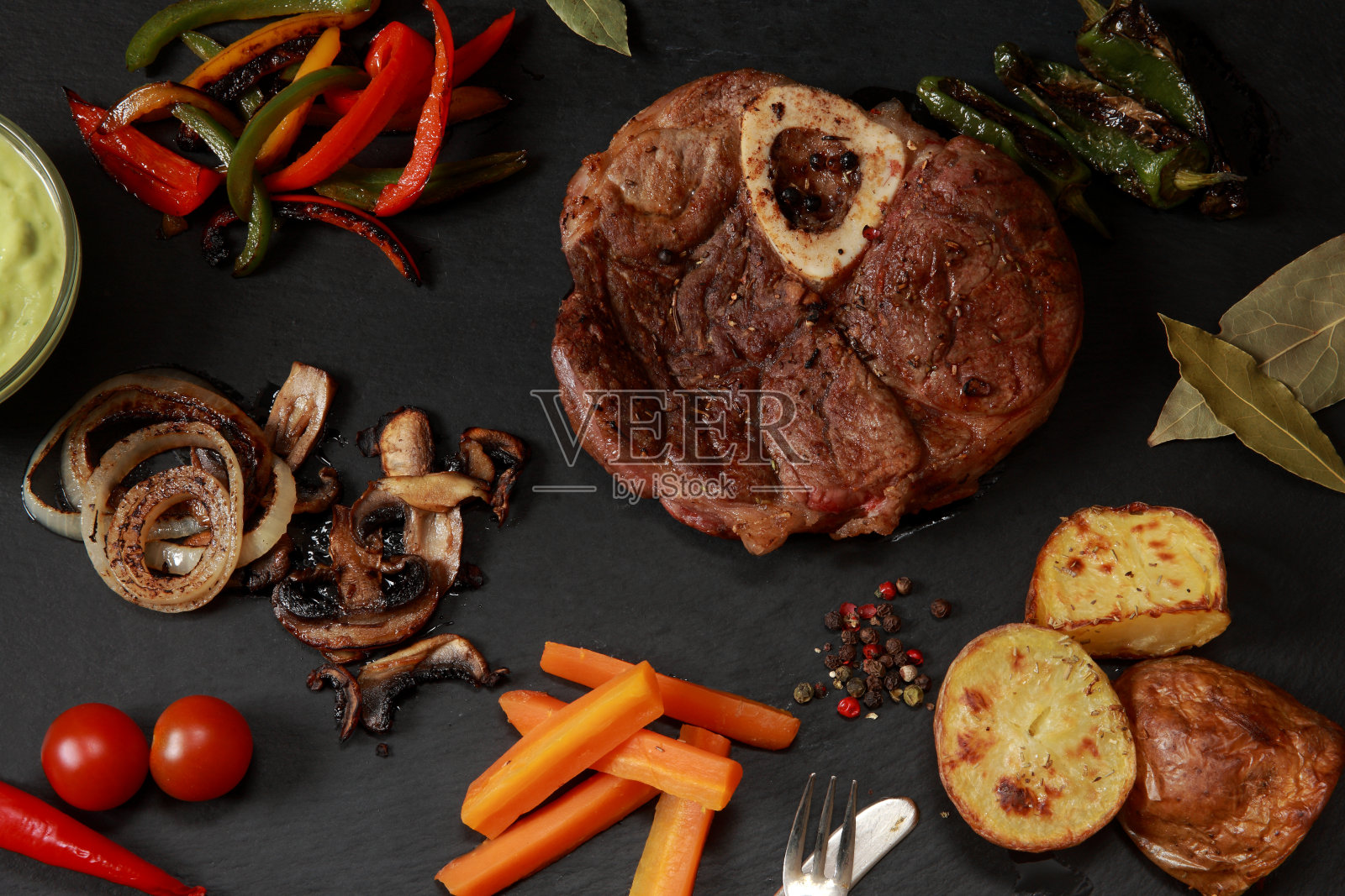 肋眼牛排和新鲜采摘和烹饪蔬菜在石板拼盘照片摄影图片