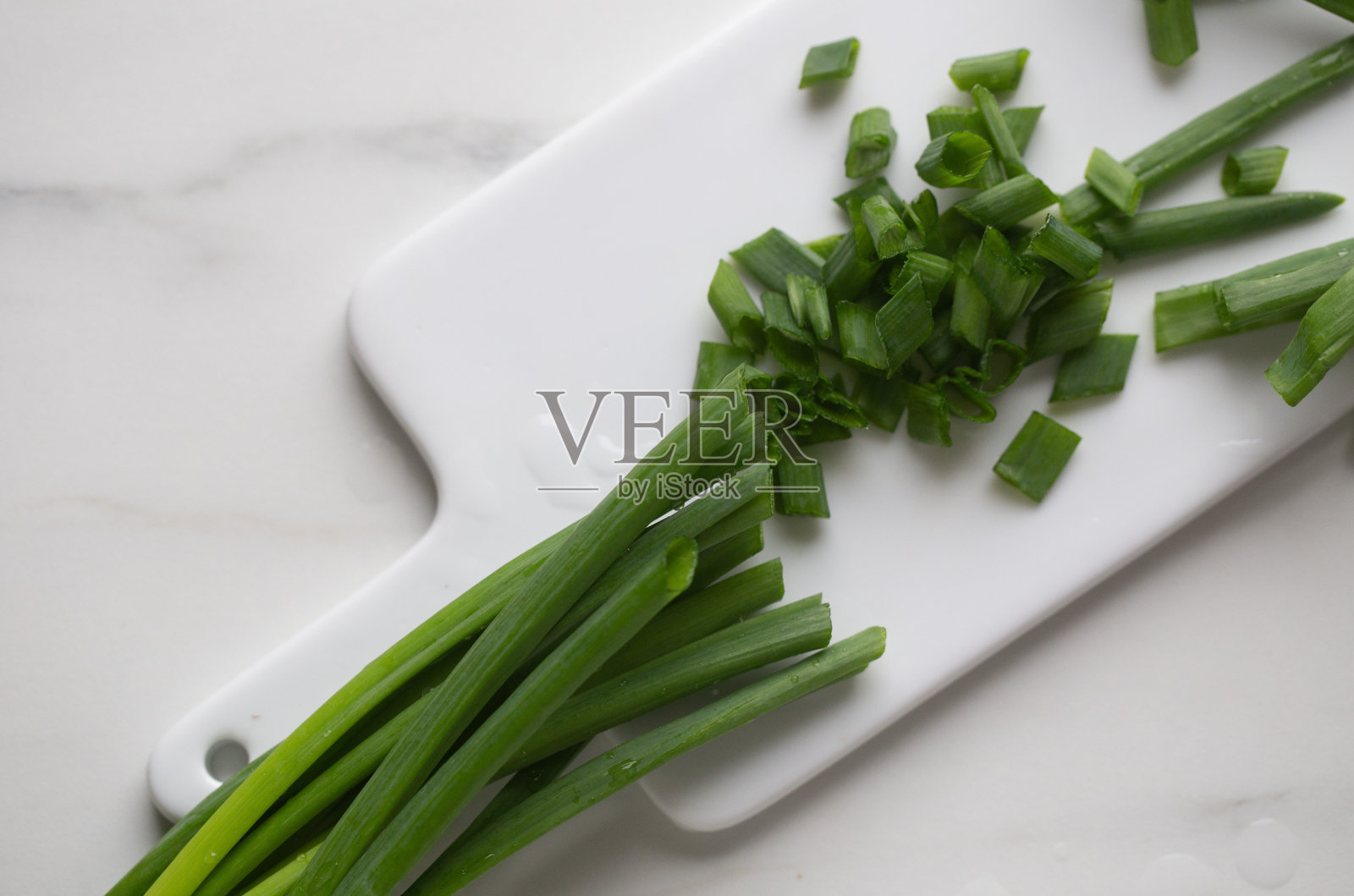白色大理石背景下的整个切碎的大葱照片摄影图片