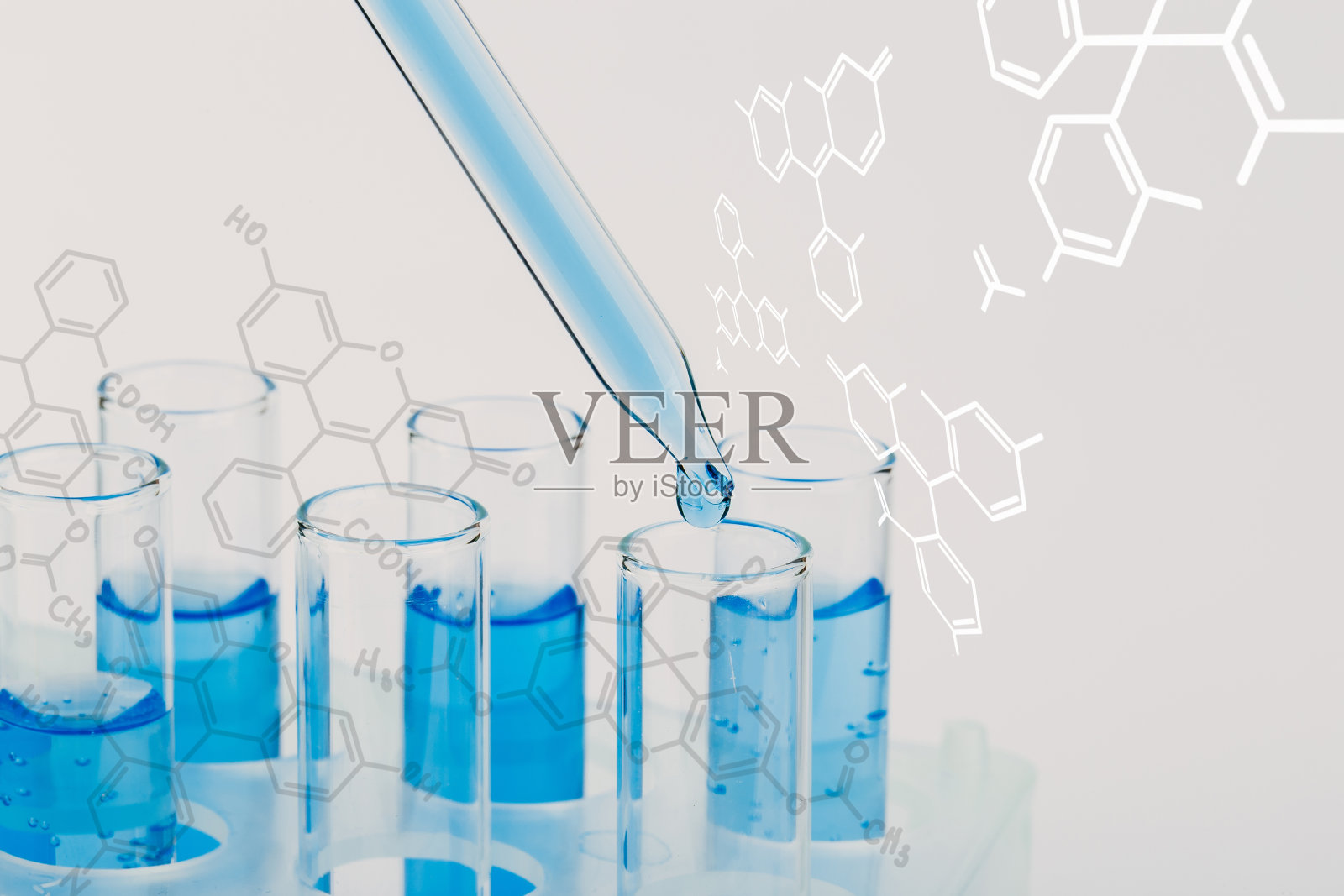 用滴管将液体滴入试管的实验室玻璃器皿。科学实验室试管，实验室设备照片摄影图片