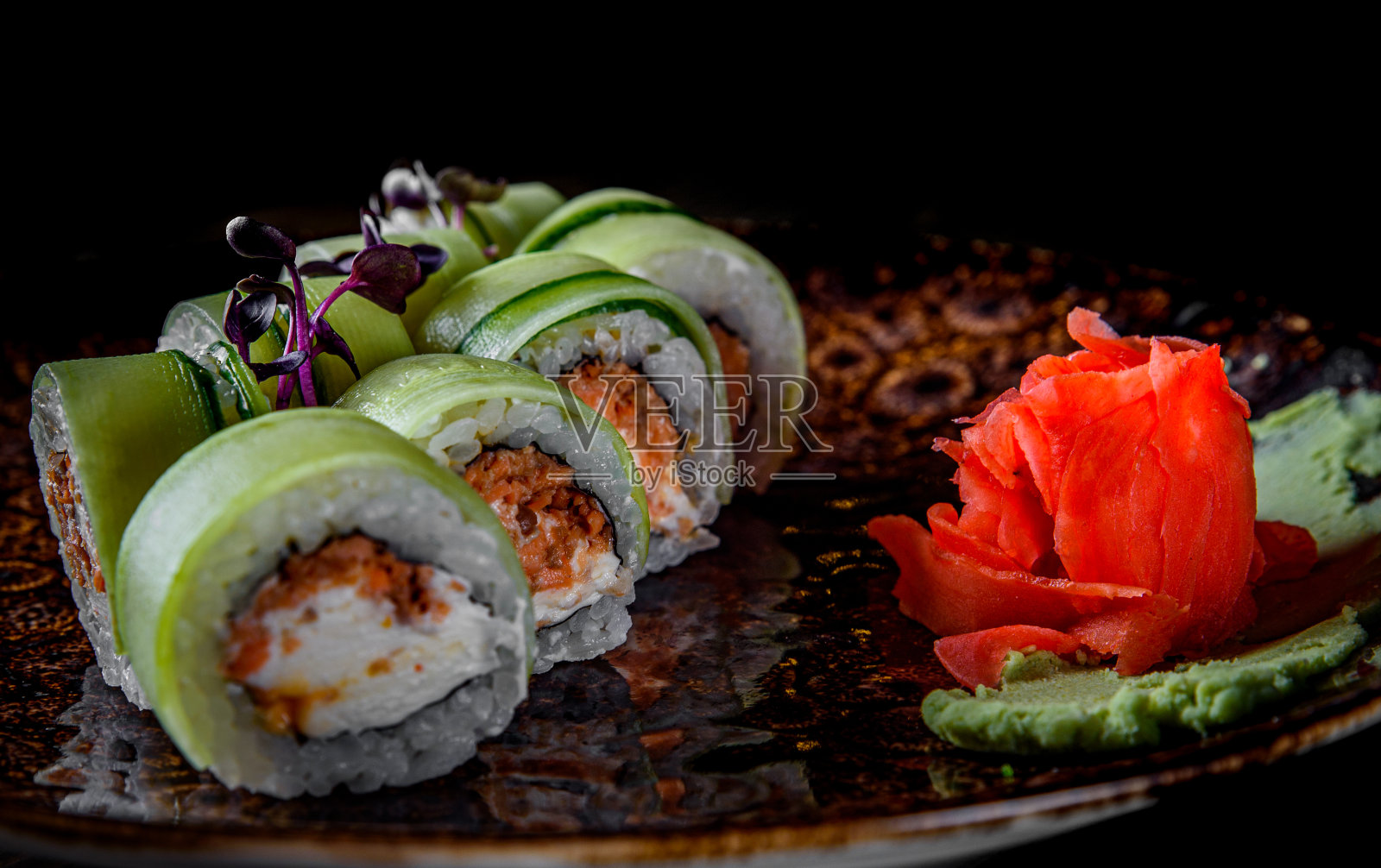 寿司卷配金枪鱼，黄瓜，奶油芝士，米饭在黑色的木桌上照片摄影图片