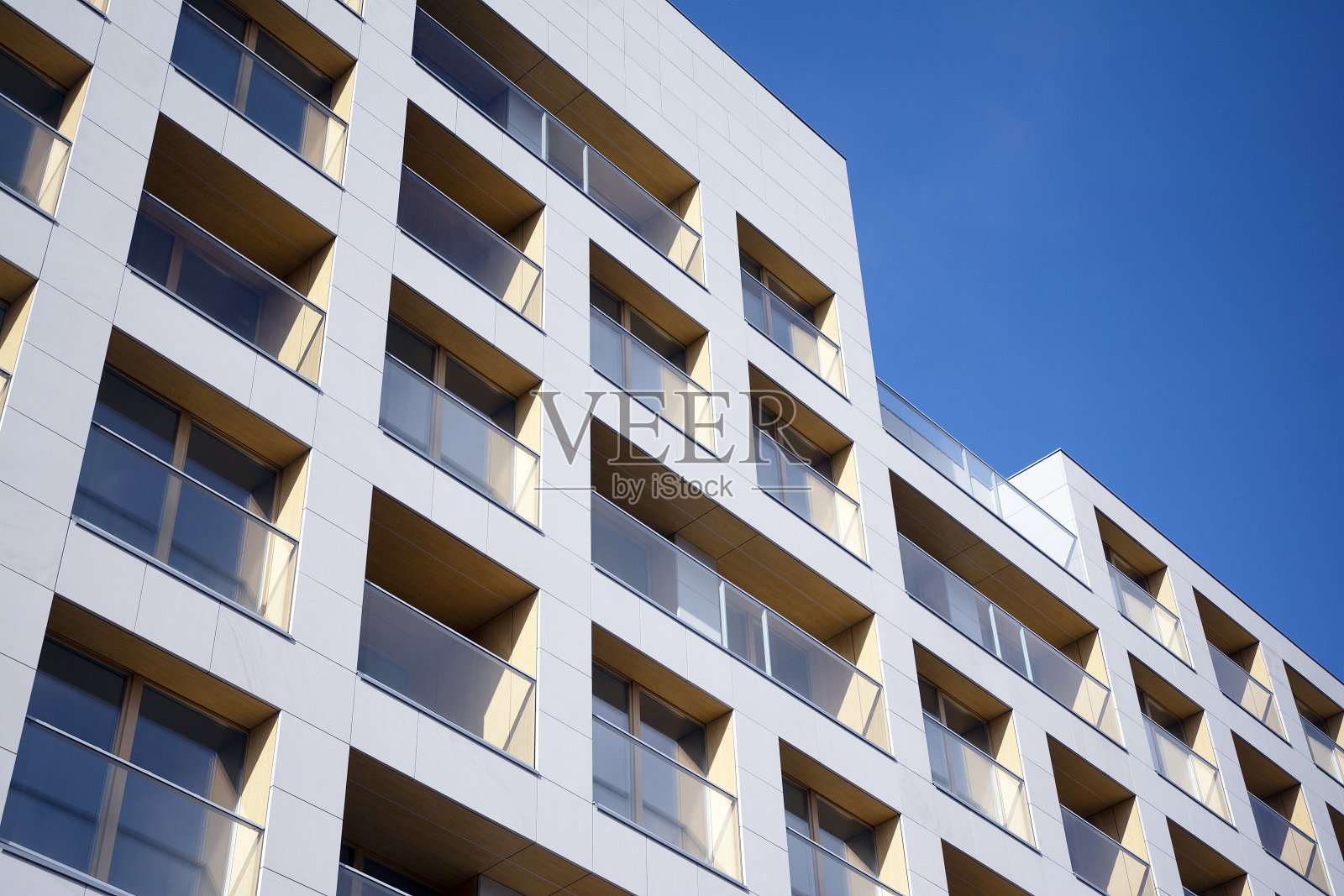 新公寓大楼的外部在蓝色多云的天空背景。照片摄影图片