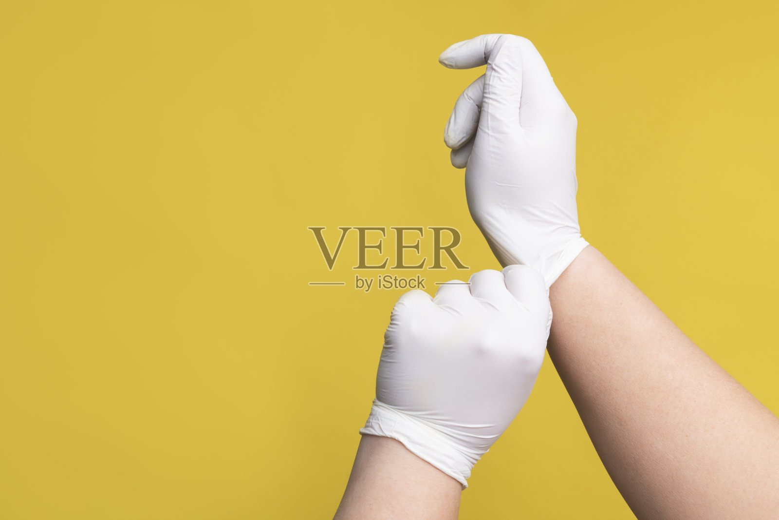 人类的双手戴上了黄色的橡胶手套照片摄影图片