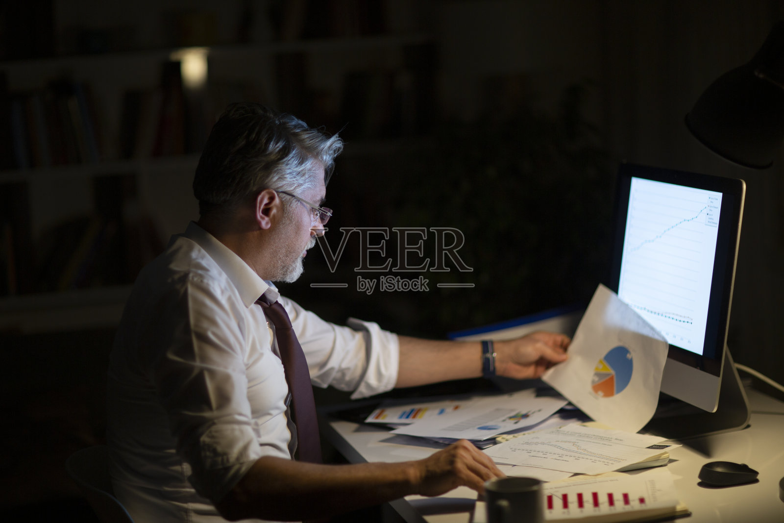 男人在家里写待办事项清单，晚上在办公室工作照片摄影图片