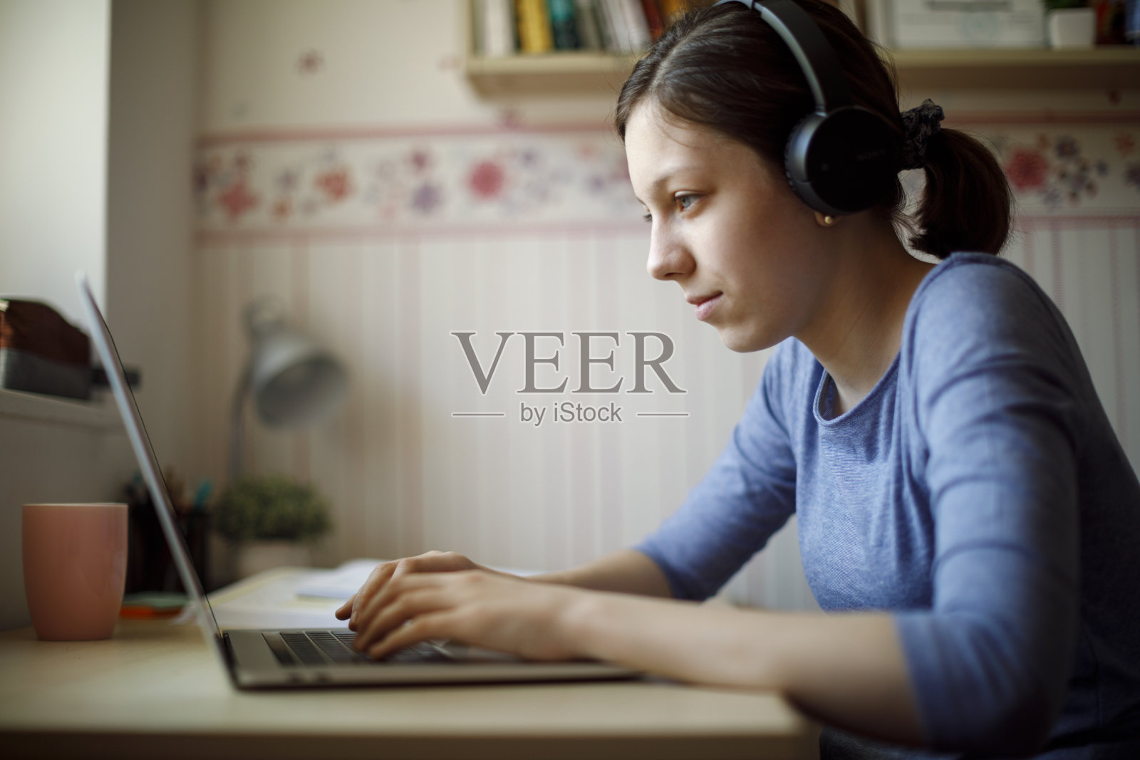 在家使用笔记本电脑学习的少女照片摄影图片