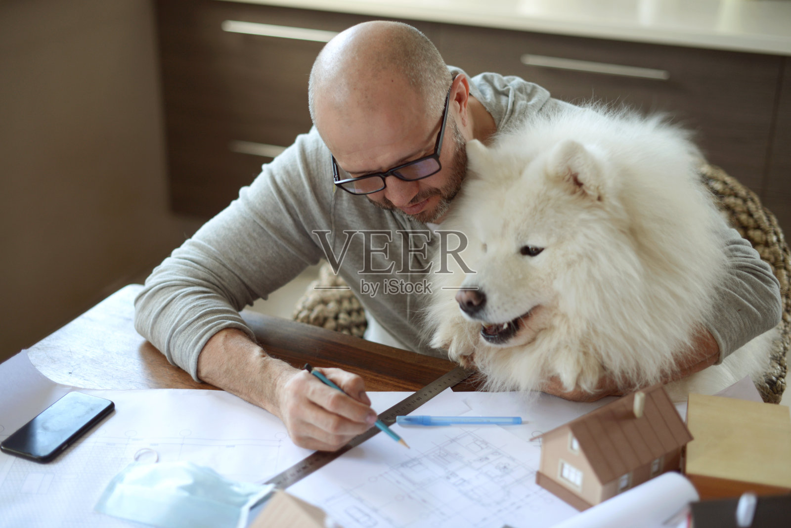 一个成熟的成年人在家里和狗一起工作照片摄影图片