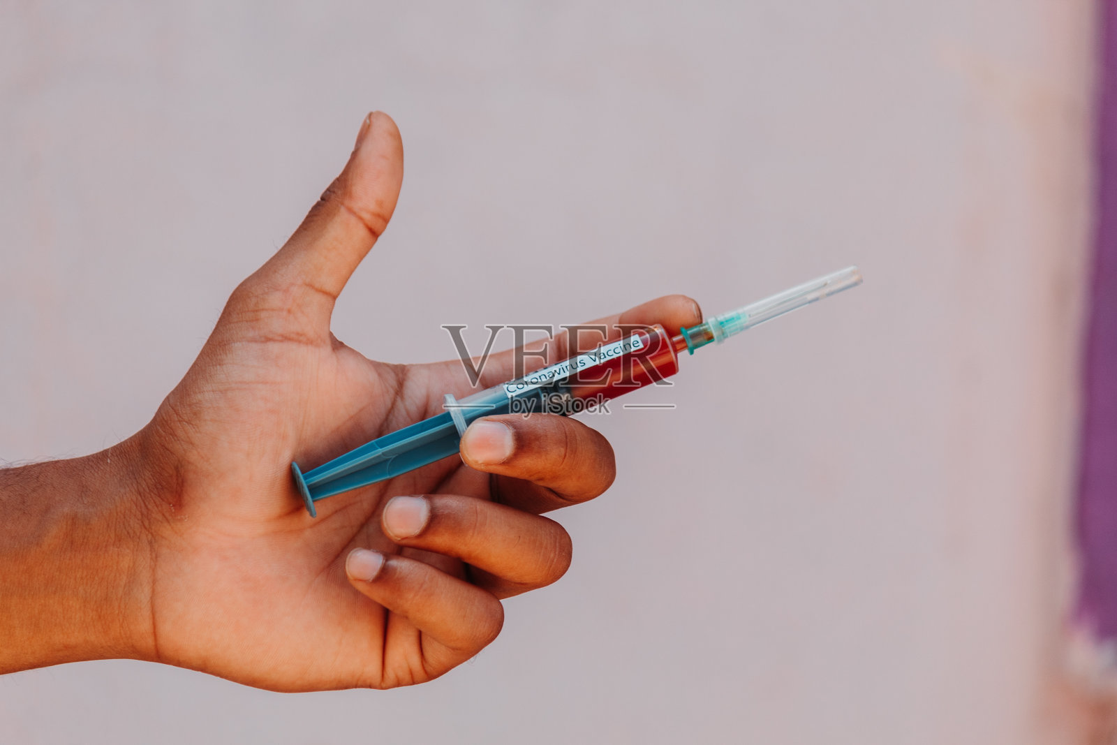 手拿含有冠状病毒疫苗的针剂照片摄影图片