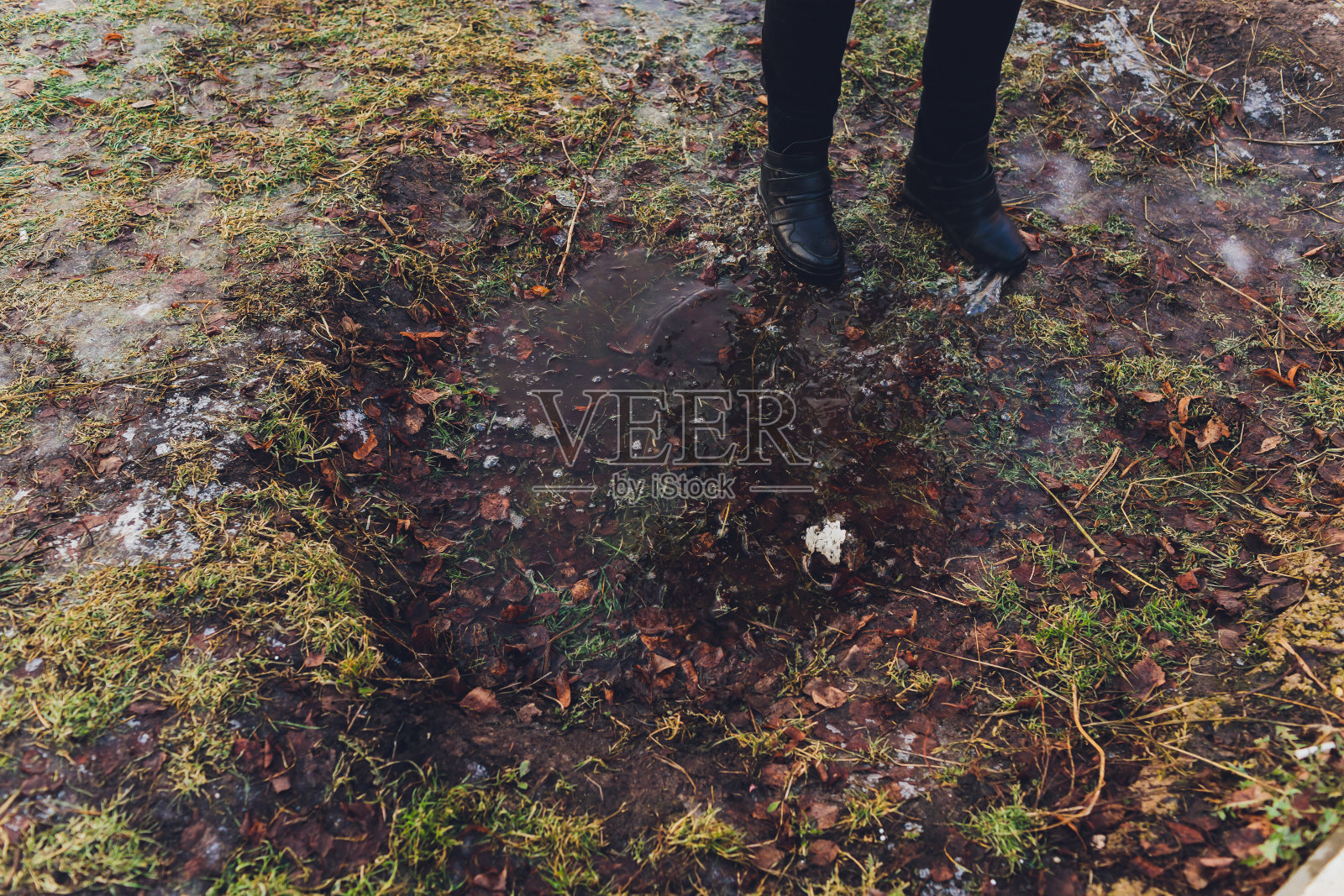 年轻女子在水坑里洗腿。照片摄影图片