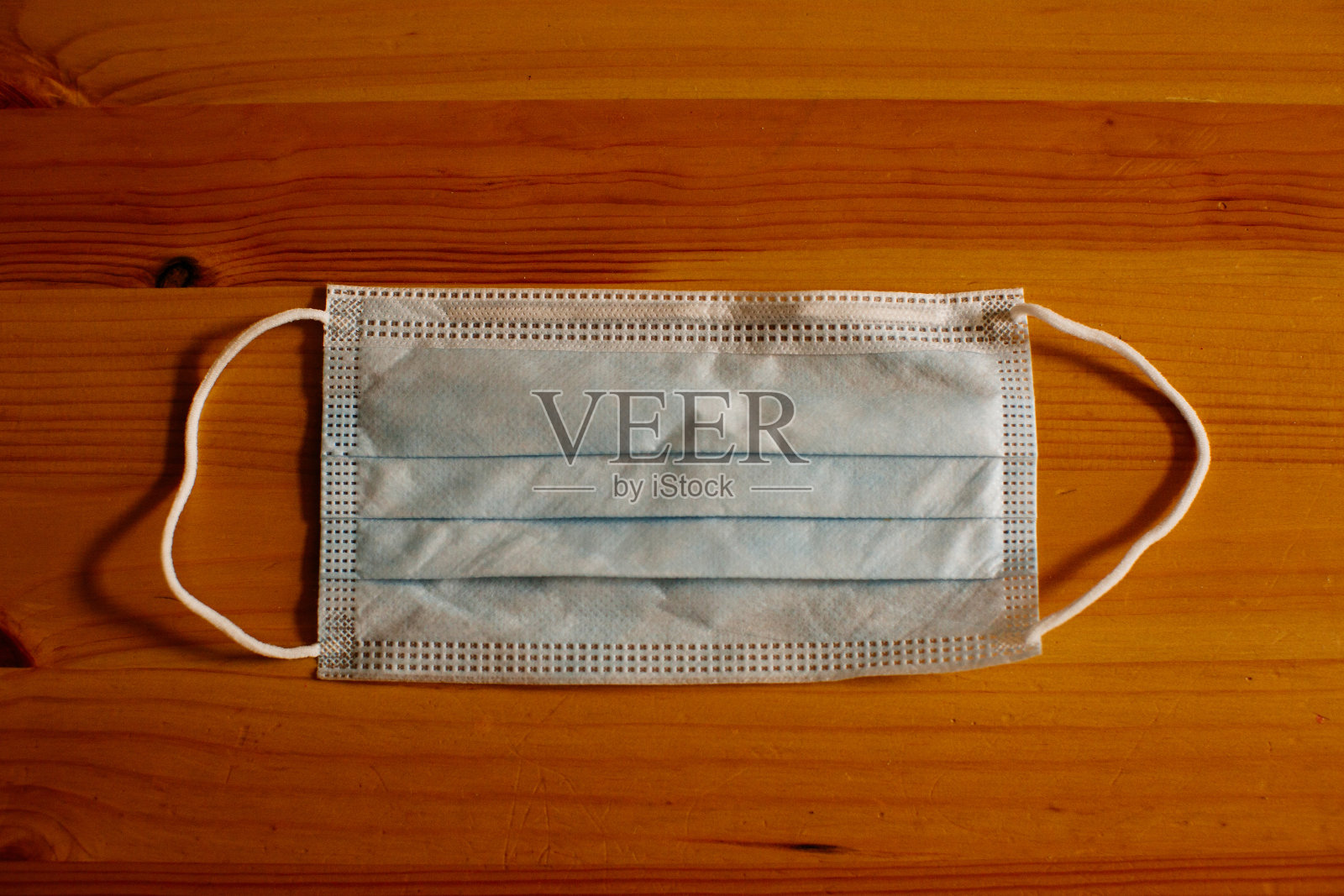 用于因冠状病毒引起的社交距离的防毒外科口罩放置在木桌上照片摄影图片