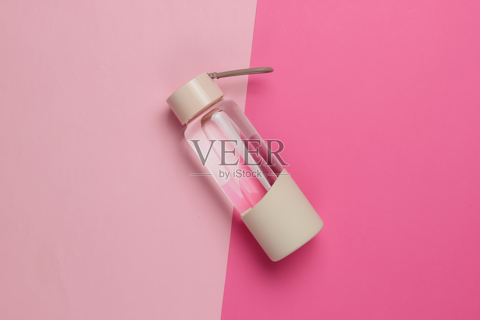 一瓶水的运动和户外活动的粉红色柔和的背景。俯视图照片摄影图片