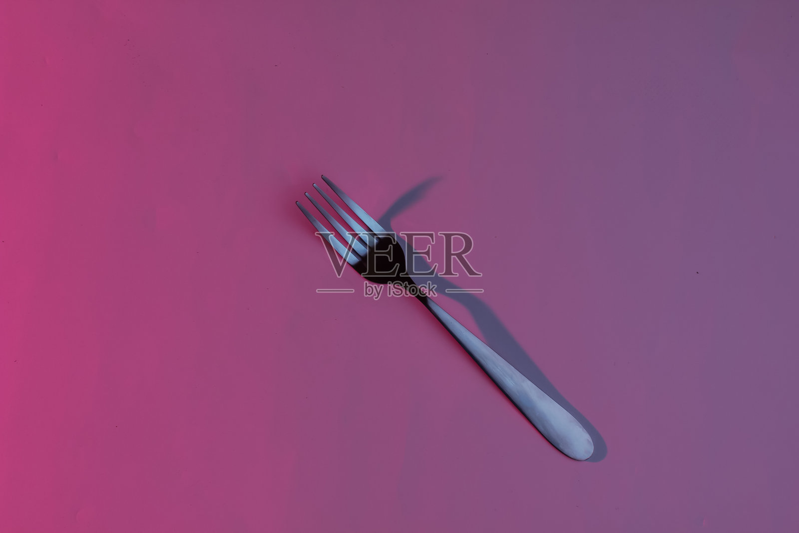 一个钢铁叉。霓虹粉蓝色夜灯照片摄影图片