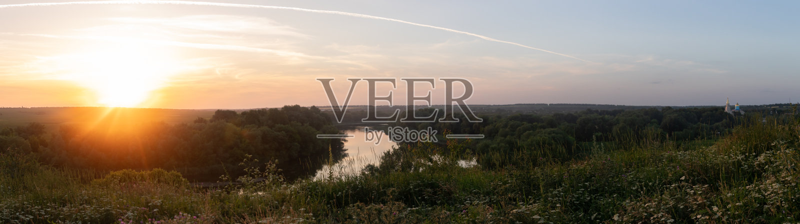 地平线上的日落。全景拍摄。一条被绿树环绕的弯曲的河流照片摄影图片