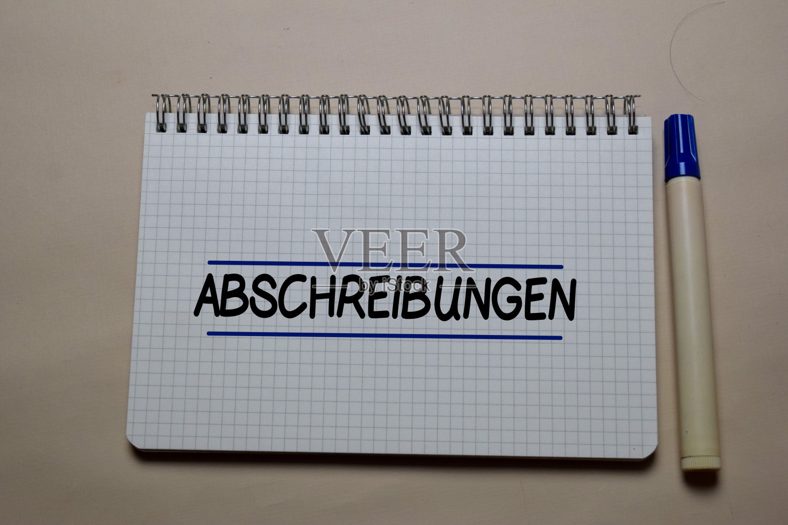 Abschreibungen写在一本孤立在办公桌上的书上。德语意思是贬值照片摄影图片