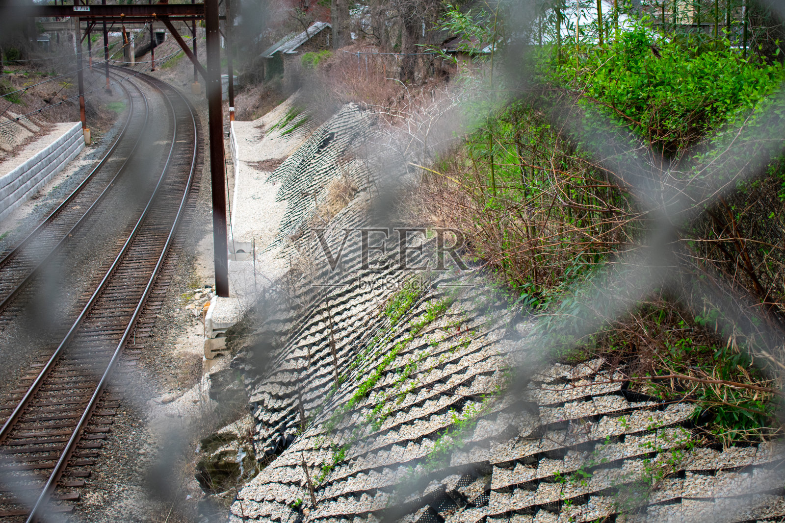 透过铁链围栏看火车轨道照片摄影图片