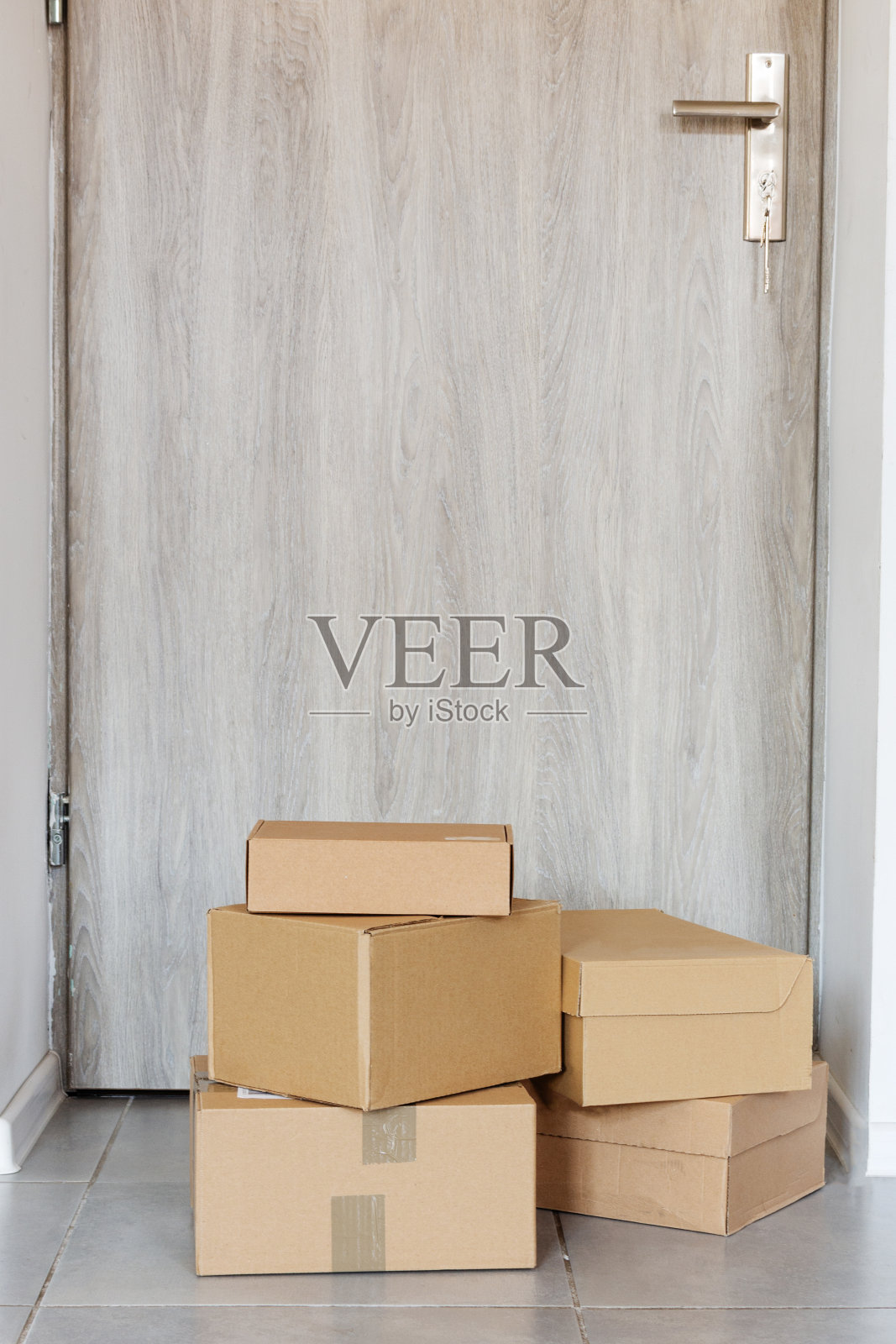 用纸板箱装的包裹放在户外门边。照片摄影图片