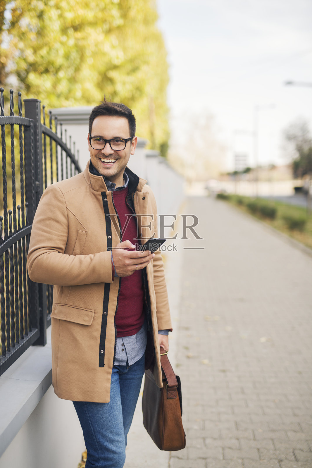 站在街上拿着手机的商人照片摄影图片