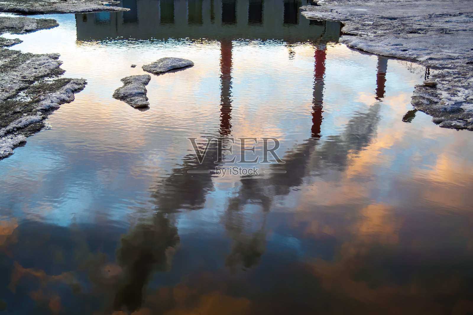 三个烟囱的烟在水坑里反射。工业管道。空气污染的概念。照片摄影图片