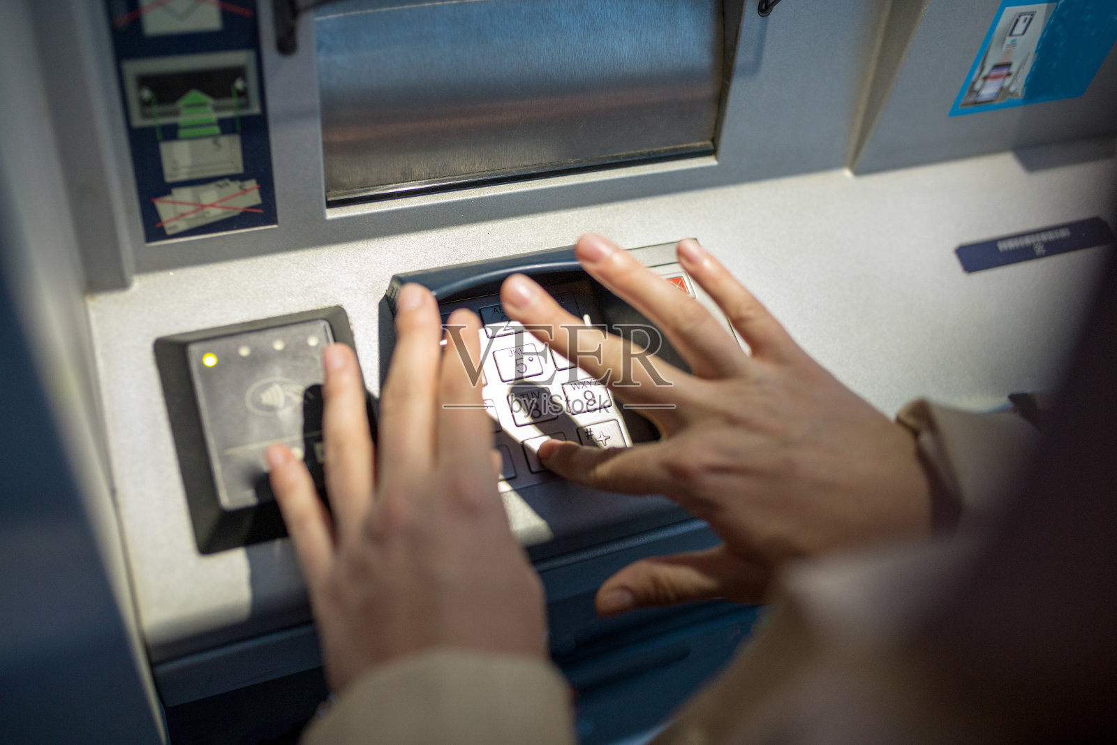 年轻女子将信用卡插入自动取款机照片摄影图片