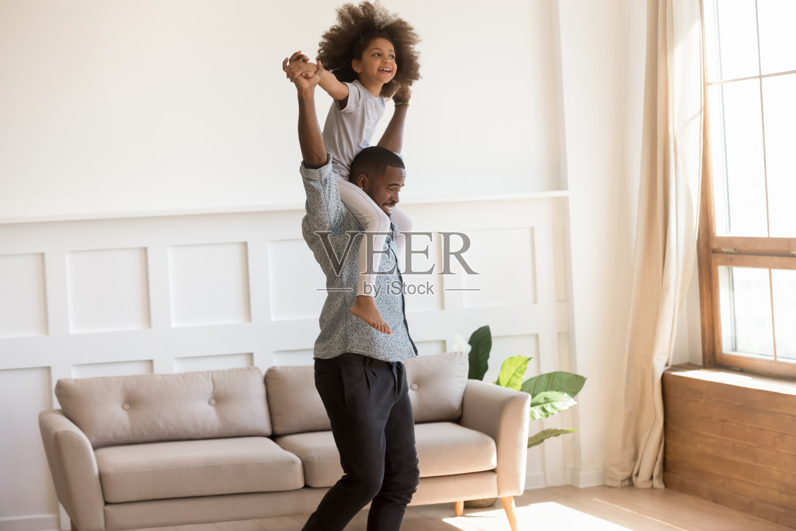 小女孩坐在爸爸的肩膀上在室内玩照片摄影图片