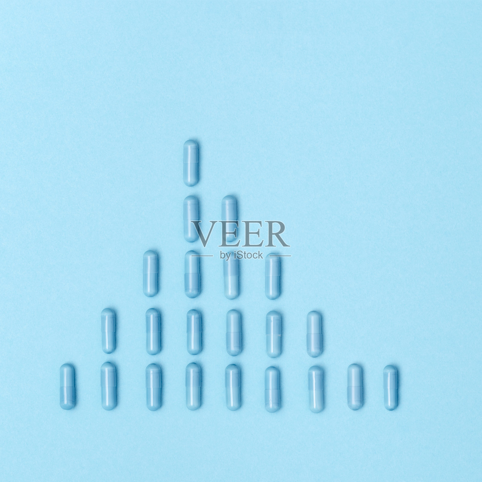 冠状病毒的发病率增长图由药片、胶囊构成，以蓝纸为背景。医疗、制药和保健理念。照片摄影图片