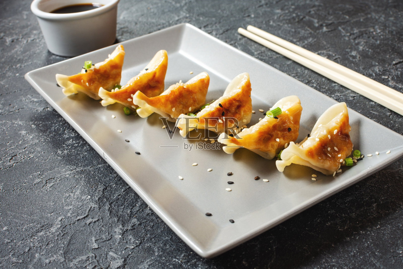 日本饺子或小吃酱油在黑色的石头背景照片摄影图片