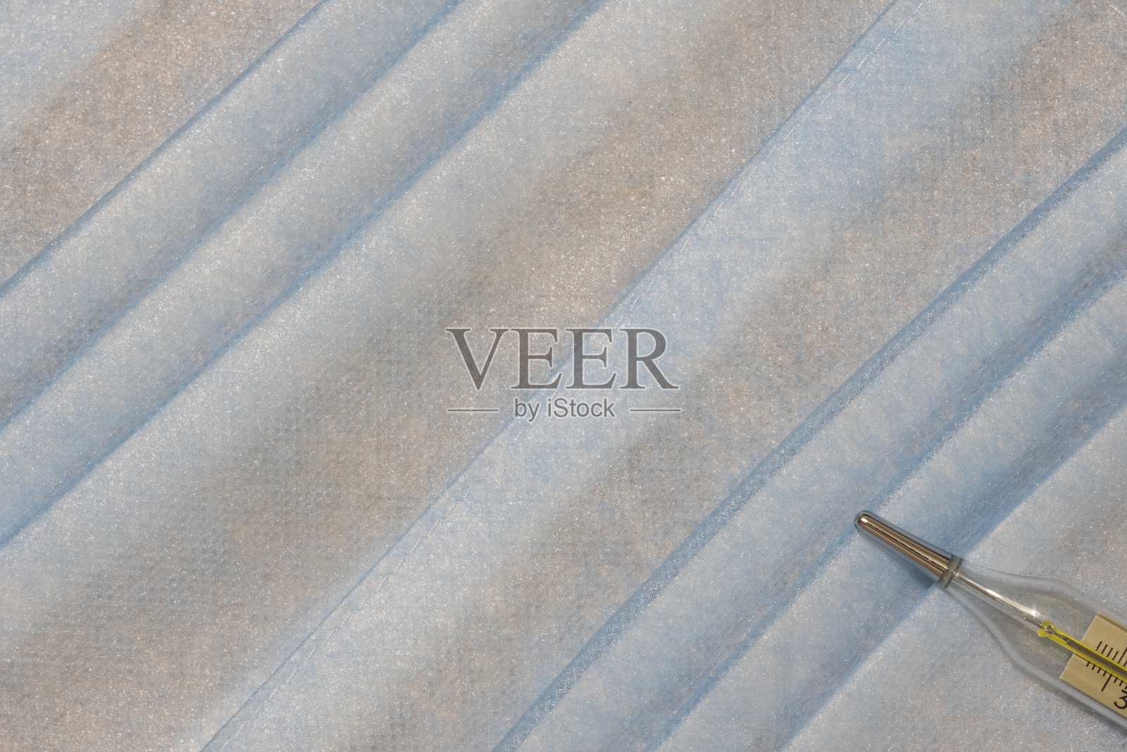 简单的医疗保健背景柔和的蓝色粉彩织物纹理和温度计诊断对象在角落，这里为您的文本复制空白空间照片摄影图片