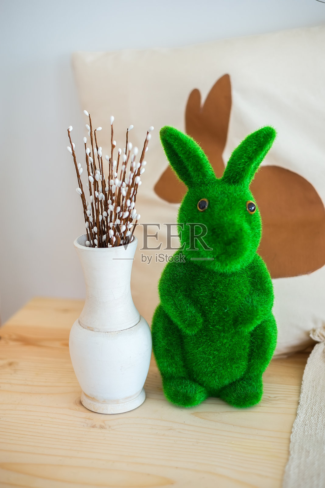 复活节家庭内部。花瓶与猫咪柳条和兔子在一个明亮的背景照片摄影图片