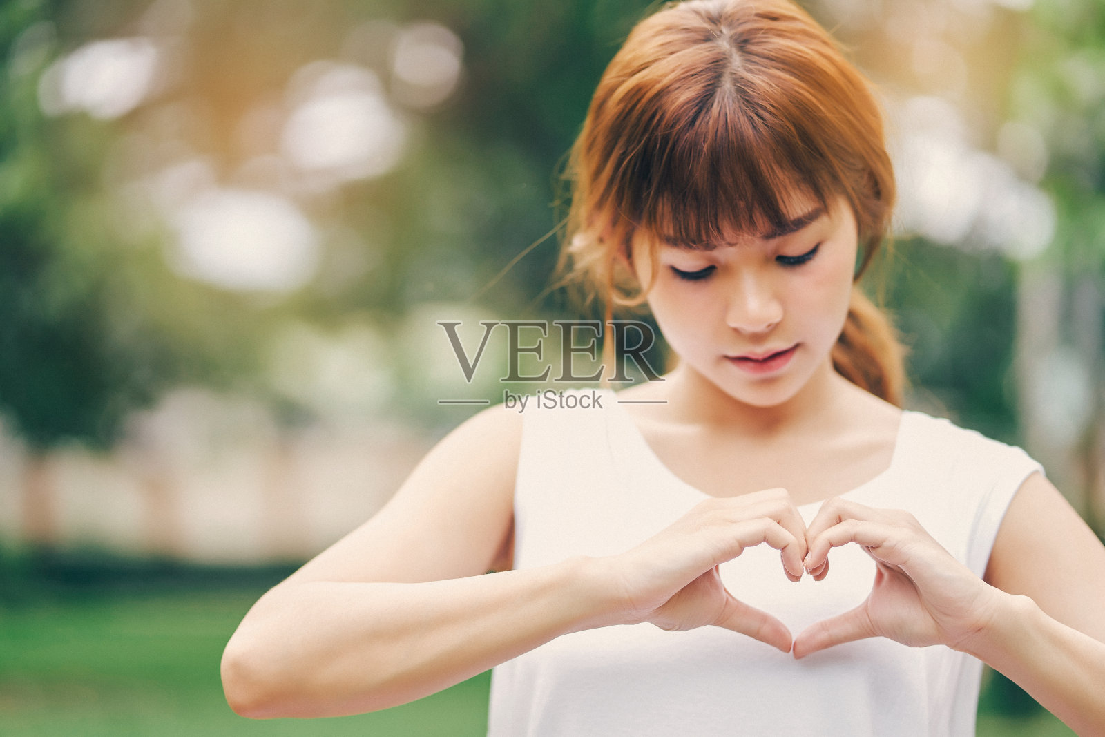 年轻女性用手做成的心形。爱情象征的概念。照片摄影图片