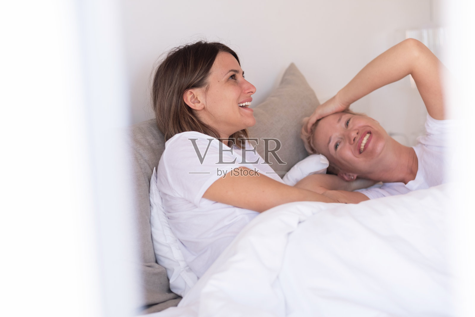 两个相爱的女人在一个阳光明媚的早晨在她们舒适的床上醒来照片摄影图片