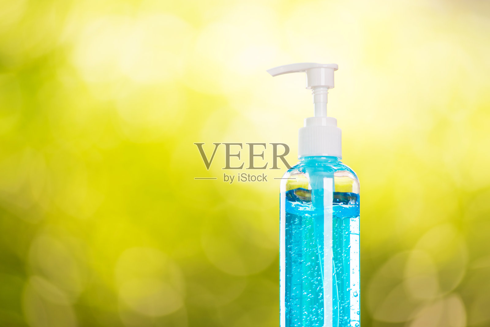 瓶蓝色发胶或酒精凝胶，以绿色bokeh自然为背景，美容保健，保护冠状病毒covid - 19照片摄影图片