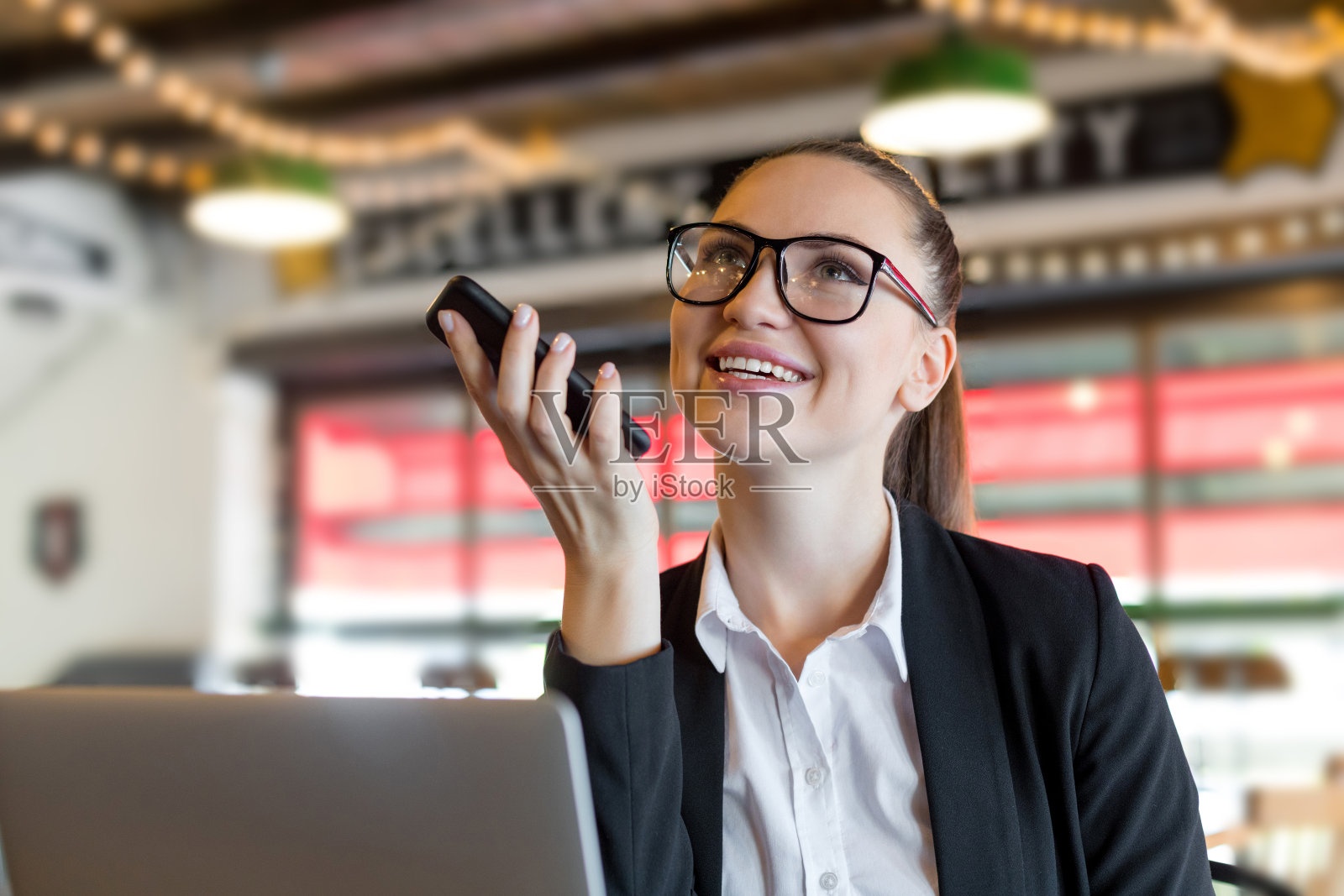 使用手机语音识别的年轻女商人照片摄影图片