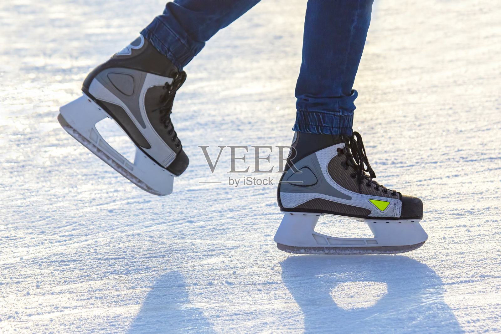 在溜冰场上滑冰的人的腿。业余爱好和体育。假期和冬季活动。照片摄影图片