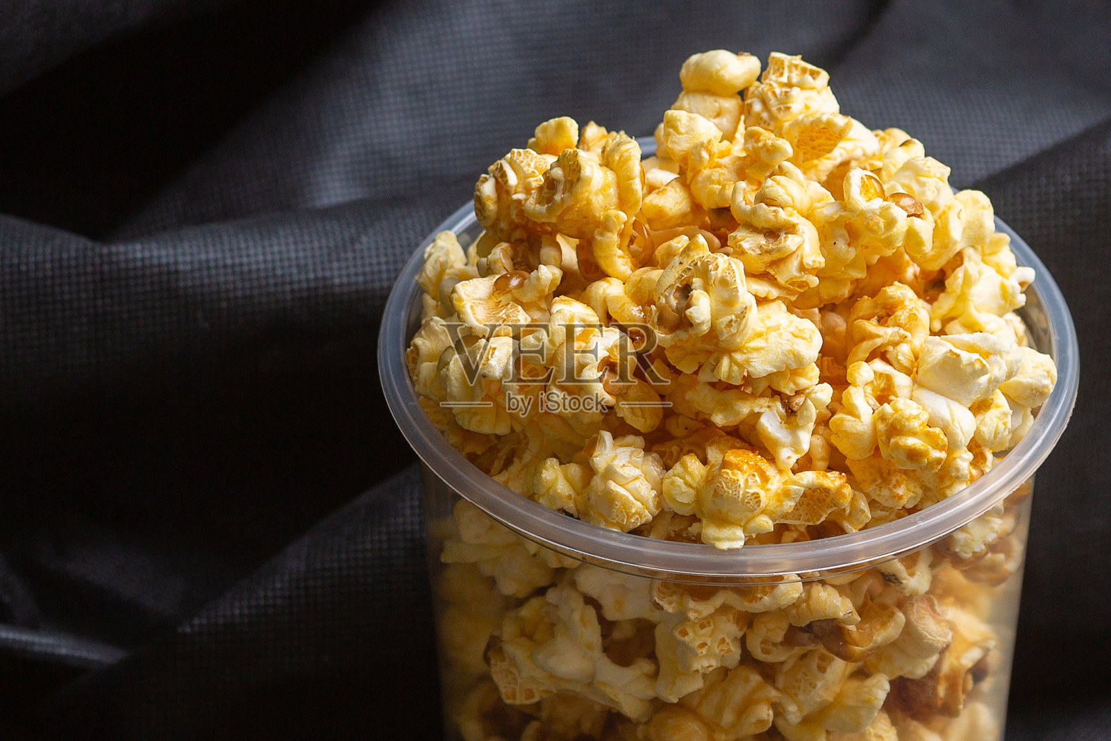 爆米花放在一个大桶里。照片摄影图片
