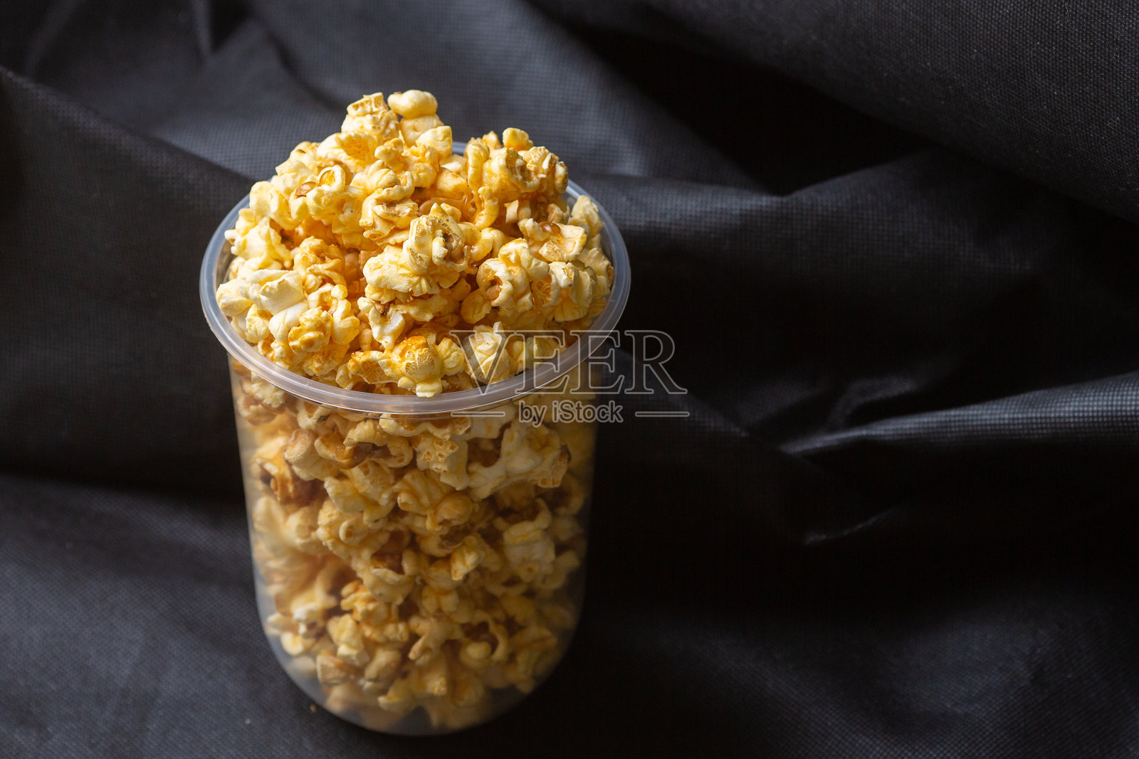 爆米花放在一个大桶里。照片摄影图片