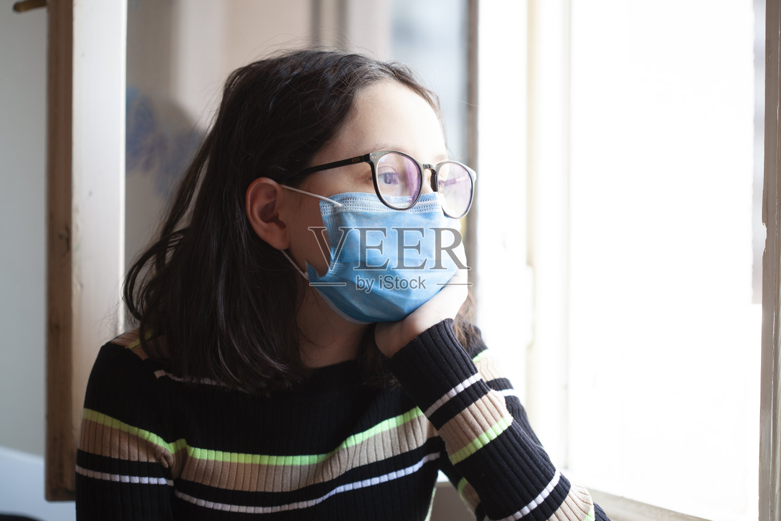 疫情期间，戴蓝色口罩的居家少女照片摄影图片