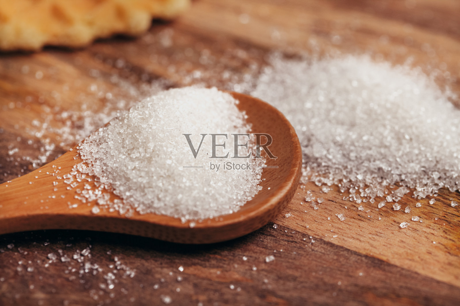 桌子上有一个放糖的木勺，勺后放着一杯茶照片摄影图片