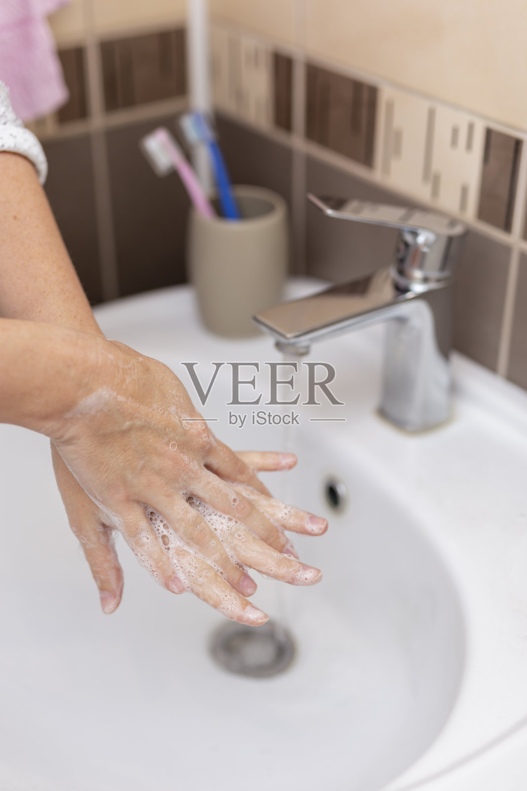 女人用肥皂和热水洗手照片摄影图片