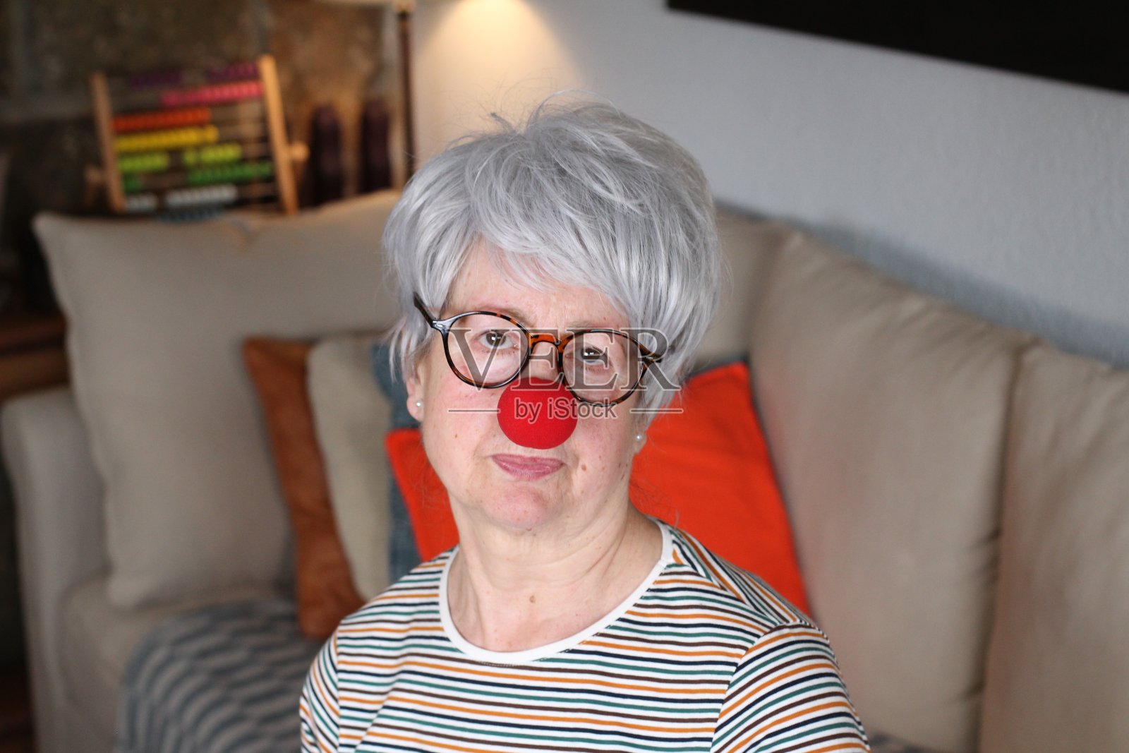 戴着小丑鼻子的老年妇女照片摄影图片